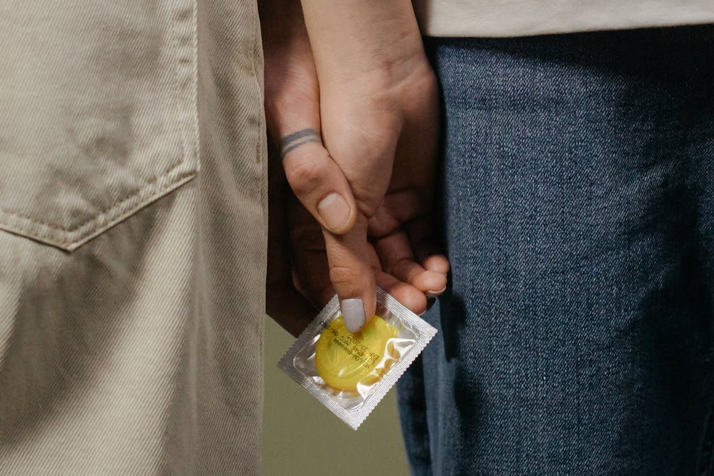 Couple Holding Hands and a Condom